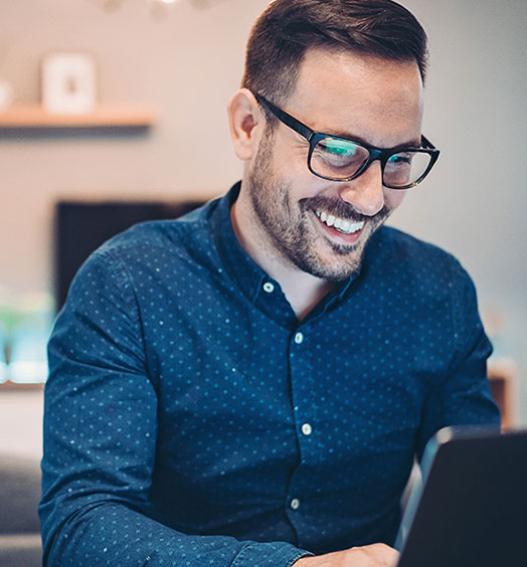 Businessman smiling while working on his laptop