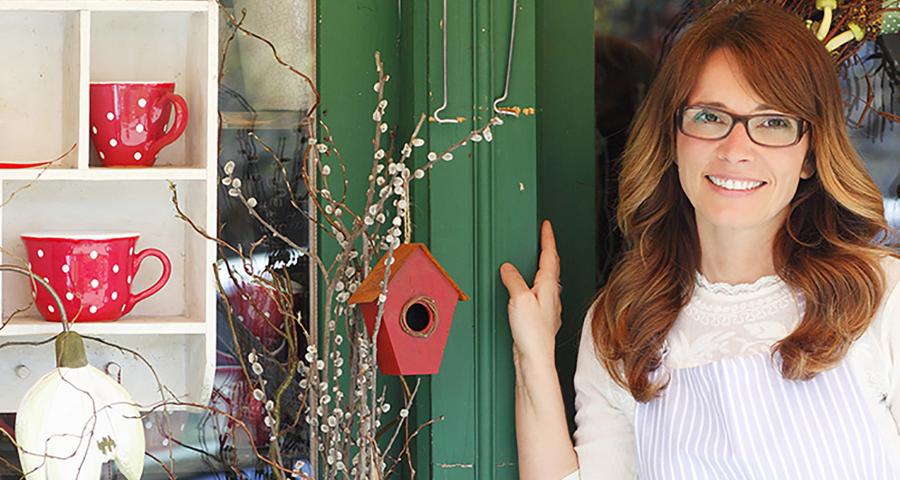 Woman posing on front of a Christmas display and smiling at the camera