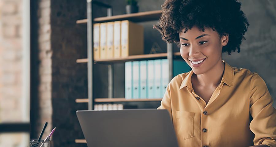 Woman smiling while working on a laptop