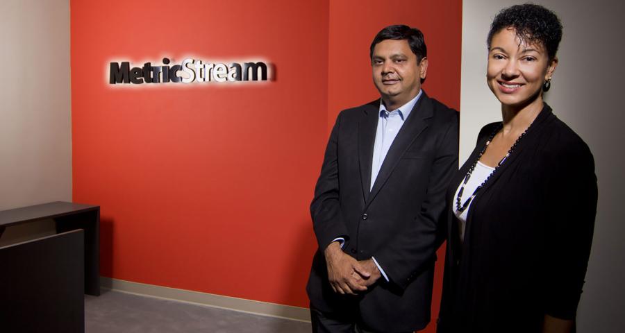 A businesswoman and man pose in the metricstream office lobby