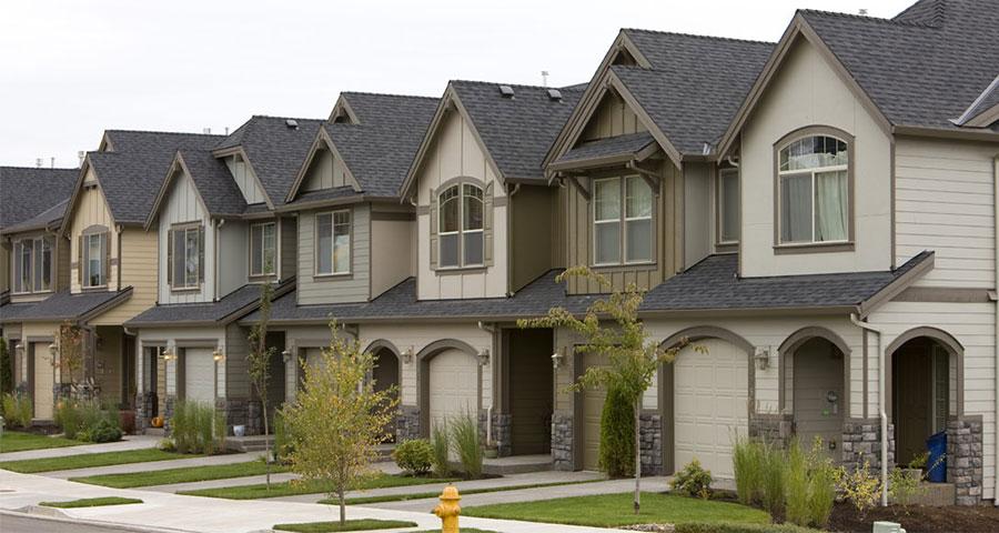 View of suburban homes with green lawns from the street