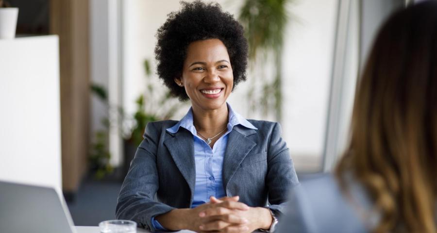 Businesswoman sitting in a chair smiling at the camera