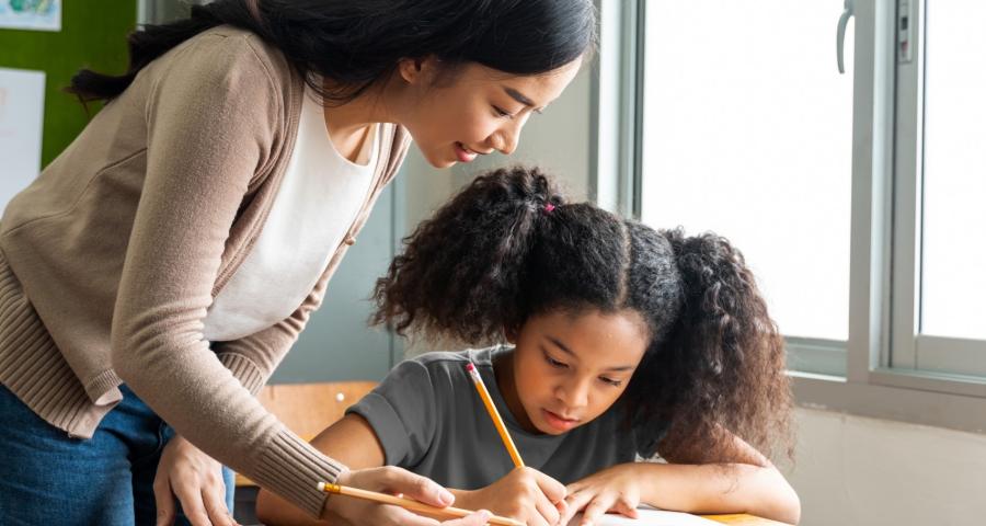 Woman helping a child with her school work