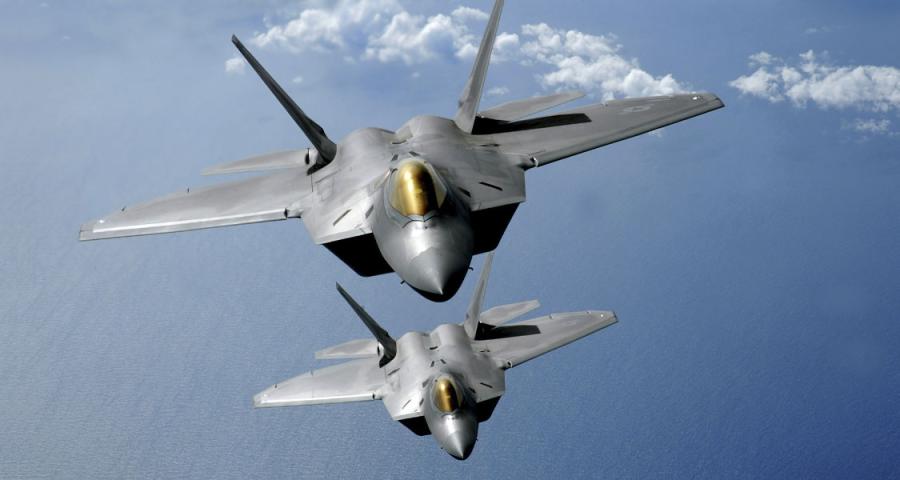 Two F-22 Raptors fly over the Pacific Ocean during a theater security mission as part of a deployment to Andersen Air Force Base, Guam