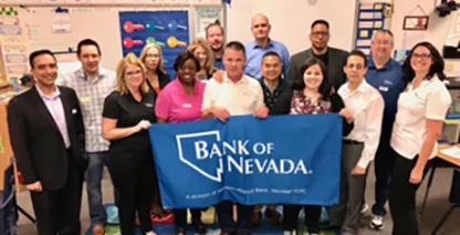 A group of people, including Bank of Nevada employees, posing in a classroom