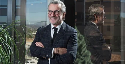CEO with arms crossed standing in front of glass office
