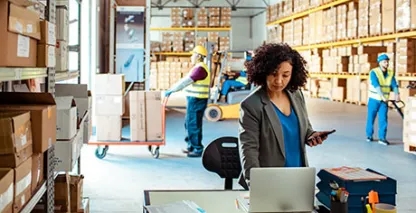 Woman looking at her computer in a warehouse