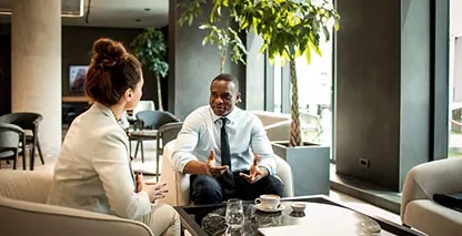 Woman and man sitting down and having a meeting.