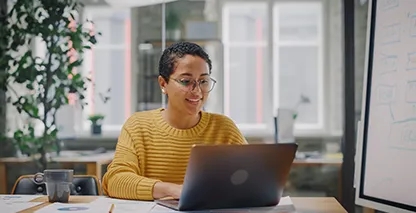 Young woman sitting at a desk on a laptop computer.