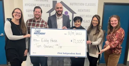 A group of nonprofit employees holding a large donation check