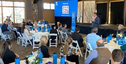 A man speaking to a room full of convention attendees