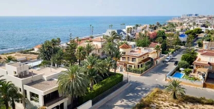 Large houses and condominiums along a sunny, tropical beach