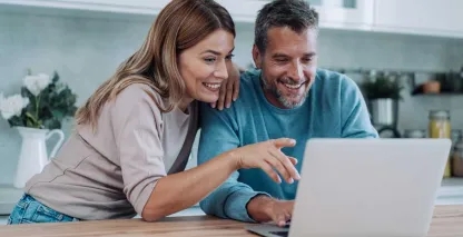 A man and woman looking at their bank account on a laptop
