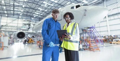 Two aerospace professionals meeting in an aircraft hangar
