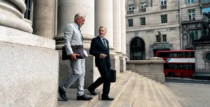Two men walking down stairs outside a building