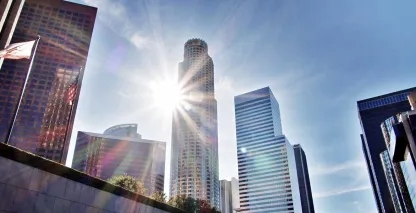 Downtown skyline with modern skyscrapers and sunburst shining between high-rise buildings