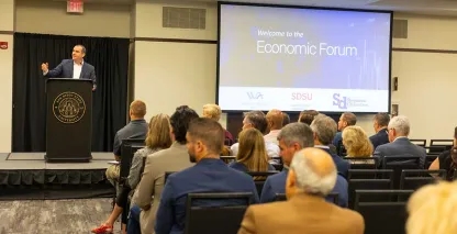 Speaker addressing attendees at an economic forum conference hosted at San Diego State University