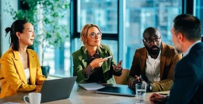 Business professionals meeting around a conference table in a modern office.