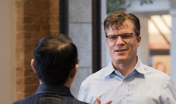 Two businessmen speaking to each other in an office setting