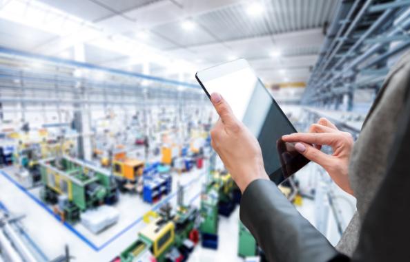 Photo illustration of a person holding a tablet computer with a wharehouse floor in the background