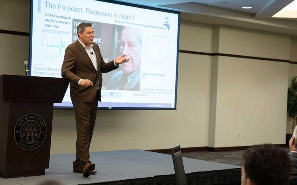 Dr. Christopher Thornberg giving a presentation on the economy to a room full of finance professionals