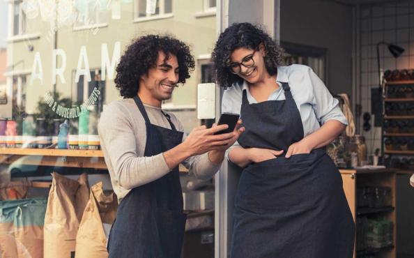 Two entrepreneurs banking on a mobile device