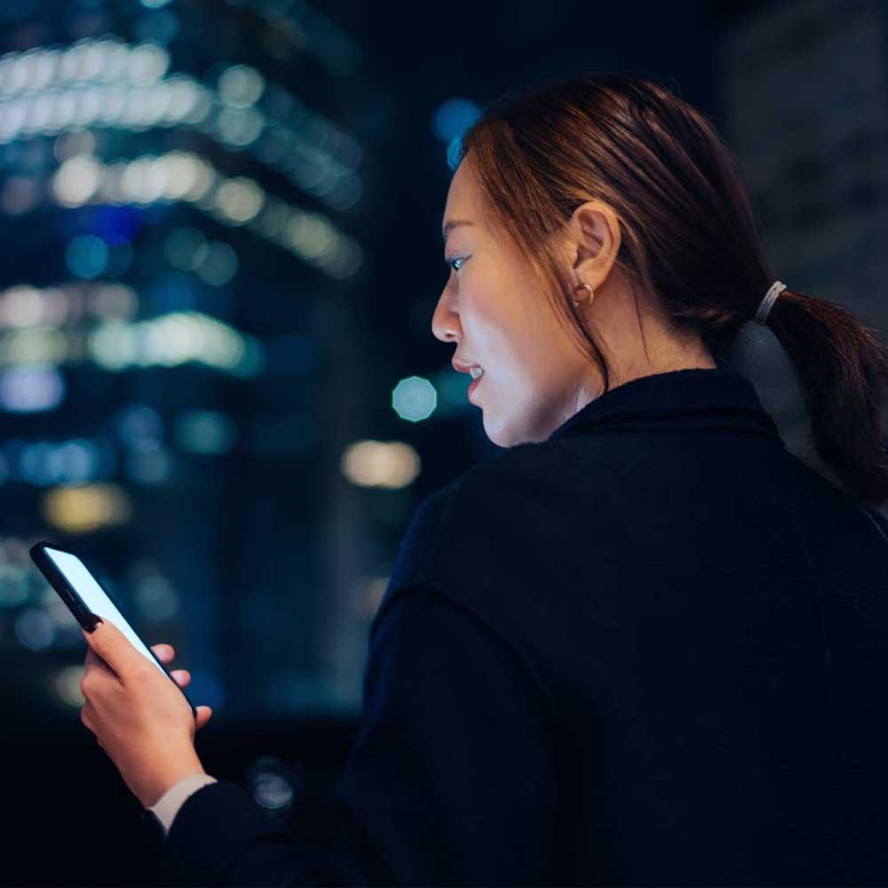 A businesswoman checking the value of her cryptocurrency on her mobile phone