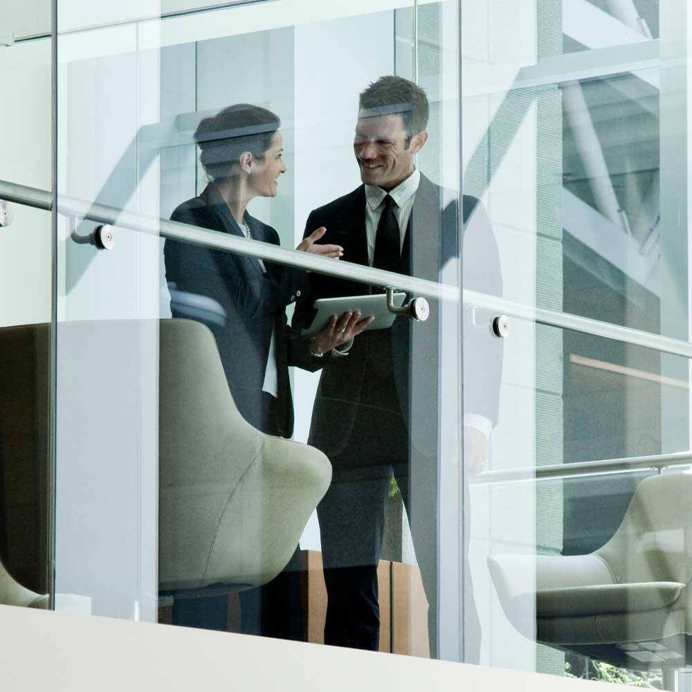 Escrow banking specialists meeting in a bright hallway